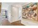 Hallway with wood floors and colorful tapestry that leads to an outdoor living space at 235 Cocoanut Ave # 108B, Sarasota, FL 34236