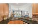 Well-equipped kitchen with granite countertop, tile backsplash, wood cabinets, and open to living room at 235 Cocoanut Ave # 108B, Sarasota, FL 34236