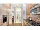 Modern kitchen featuring stainless steel appliances, tile backsplash, and wood flooring leading to the laundry area at 235 Cocoanut Ave # 108B, Sarasota, FL 34236