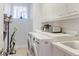Bright laundry room with white cabinets, sink, and modern washer and dryer at 235 Cocoanut Ave # 108B, Sarasota, FL 34236