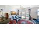 Bright living room with blue leather seating, decorative rug, and a large window with neighborhood view at 235 Cocoanut Ave # 108B, Sarasota, FL 34236