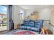 Bright living room with blue leather seating, decorative rug, and a large window with neighborhood view at 235 Cocoanut Ave # 108B, Sarasota, FL 34236