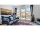Bright living room with blue leather seating, decorative rug, and a large window with neighborhood view at 235 Cocoanut Ave # 108B, Sarasota, FL 34236