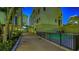 Community pool is surrounded by a black fence and lush landscaping at 235 Cocoanut Ave # 108B, Sarasota, FL 34236