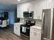 Modern kitchen with stainless steel appliances, white cabinets, and ample counter space at 2726 Knoll E St, Palm Harbor, FL 34683