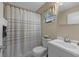 Bathroom featuring shower with curtains, sink, toilet, window and mirror at 2749 Riverbluff Pl # V65, Sarasota, FL 34231