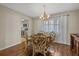 Cozy dining room with hardwood floors, chandelier, and window with sheer curtains at 2749 Riverbluff Pl # V65, Sarasota, FL 34231