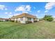 Single-story home featuring a green lawn, mature landscaping and an asphalt driveway at 2749 Riverbluff Pl # V65, Sarasota, FL 34231