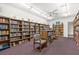 Cozy library featuring extensive bookshelves filled with books and comfortable seating for reading and relaxation at 2749 Riverbluff Pl # V65, Sarasota, FL 34231