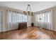 Bright living room featuring wood floors, a chandelier, and large windows with sheer curtains at 2749 Riverbluff Pl # V65, Sarasota, FL 34231