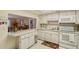 Bright kitchen features white cabinets, appliances, and an eat-in bar looking into the living area at 3705 S School Ave # 3, Sarasota, FL 34239