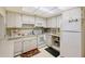 Bright kitchen features white cabinets, appliances, and recessed lighting providing a clean and efficient cooking space at 3705 S School Ave # 3, Sarasota, FL 34239