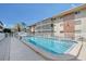 Exterior view of a lovely community pool surrounded by white fencing and lovely building architecture at 3705 S School Ave # 3, Sarasota, FL 34239