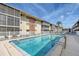 Exterior view of a lovely community pool with building architecture with screened lanais and lovely palm trees at 3705 S School Ave # 3, Sarasota, FL 34239