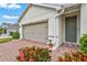 Close-up of the front exterior, showcasing the two-car garage, front door, and brick-paved walkway at 3924 Candia Ave, North Port, FL 34286