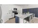 Modern kitchen with a marble island, black appliances, white cabinetry, and stylish bar stools at 3924 Candia Ave, North Port, FL 34286