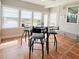 Dining area with windows overlooking water, tile flooring, complemented by a glass table and seating at 415 Oakwood W Blvd, Sarasota, FL 34237