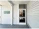Side entrance with security camera, featuring gray vinyl siding and a screen door at 415 Oakwood W Blvd, Sarasota, FL 34237