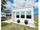 Well-maintained home featuring a clean white exterior, plenty of windows, and decorative potted plants at 415 Oakwood W Blvd, Sarasota, FL 34237
