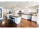 Modern kitchen with white cabinetry, stainless steel appliances, a breakfast bar, and dark countertops at 415 Oakwood W Blvd, Sarasota, FL 34237