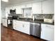 Modern kitchen with stainless steel appliances, white cabinetry, and sleek backsplash for a clean, stylish look at 415 Oakwood W Blvd, Sarasota, FL 34237