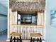 Close up of the bamboo tiki bar featuring a thatched roof and a serving counter with stools at 415 Oakwood W Blvd, Sarasota, FL 34237