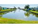 Scenic view of a tranquil canal with a fountain, lined by lush green grass, creating a serene ambiance at 415 Oakwood W Blvd, Sarasota, FL 34237
