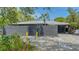 Contemporary home featuring a textured gray exterior, white tile roof, and stylish yellow decor at 4857 Stevens Dr, Sarasota, FL 34234