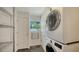 Bright laundry room with modern stacked washer and dryer, and ample storage space at 4857 Stevens Dr, Sarasota, FL 34234