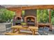 Outdoor kitchen area with picnic table, pizza oven, and grill, ideal for entertaining at 4857 Stevens Dr, Sarasota, FL 34234