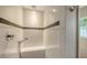 Close up of remodeled shower with white subway tile, pebble accents, and a built-in bench at 4857 Stevens Dr, Sarasota, FL 34234