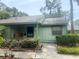 Charming single-story home with a light green exterior, front porch, and well-maintained landscaping at 5014 Barrington Cir # 2102, Sarasota, FL 34234