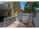 Private backyard entrance with a white fence, brick pavers, and lush landscaping at 508 Howard Ct, Sarasota, FL 34236