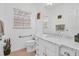 Well-lit bathroom featuring marble countertops, white cabinetry, modern fixtures, and a neutral color scheme at 508 Howard Ct, Sarasota, FL 34236