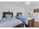 Bright bedroom with hardwood floors, two twin beds, a ceiling fan, and ensuite access to a bathroom at 508 Howard Ct, Sarasota, FL 34236