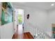 Hallway with wood floors, a white banister, and natural light from a nearby outdoor space at 508 Howard Ct, Sarasota, FL 34236