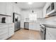 Renovated kitchen featuring stainless steel appliances, white cabinets, and updated countertops at 508 Howard Ct, Sarasota, FL 34236