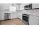 Modern kitchen featuring stainless steel appliances, white cabinets, and tile backsplash at 508 Howard Ct, Sarasota, FL 34236