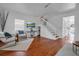 Well-lit living room with hardwood floors, white stairs, and a comfortable sitting area at 508 Howard Ct, Sarasota, FL 34236