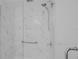 Modern shower featuring marble-like tiling, glass doors, sleek fixtures, and a convenient grab bar at 508 Howard Ct, Sarasota, FL 34236