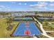 Aerial view of the blue basketball court, tennis courts, and a green putting range for community residents at 5117 Marina Basin Ct, Bradenton, FL 34211