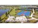 View of a bright blue basketball court, lake, and shaded seating area with lush tropical landscaping at 5117 Marina Basin Ct, Bradenton, FL 34211