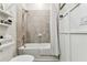 Tiled bathtub and shower combination in a modern bathroom, complemented by shelving and neutral decor at 5117 Marina Basin Ct, Bradenton, FL 34211