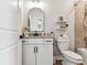 Bright bathroom featuring a modern vanity with granite countertop, arch mirror and decorative floating shelves at 5117 Marina Basin Ct, Bradenton, FL 34211