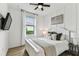 Cozy bedroom features a ceiling fan, a comfortable bed, and large window that bring in natural light at 5117 Marina Basin Ct, Bradenton, FL 34211