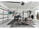 A home gym in a garage featuring a garage door, weightlifting equipment, and an open door at 5117 Marina Basin Ct, Bradenton, FL 34211