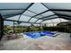 A covered pool area features lounge seating and a spa with views of the lush backyard and pond at 5117 Marina Basin Ct, Bradenton, FL 34211