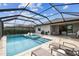 Inviting screened pool with spa, sun loungers, and outdoor kitchen area for relaxation and entertainment at 5117 Marina Basin Ct, Bradenton, FL 34211