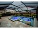 Twilight view of a sparkling, screened-in pool with spa and stylish lounge chairs at 5117 Marina Basin Ct, Bradenton, FL 34211