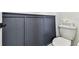Stylish powder room with dark wainscoting and modern toilet with a white storage bin at 5117 Marina Basin Ct, Bradenton, FL 34211